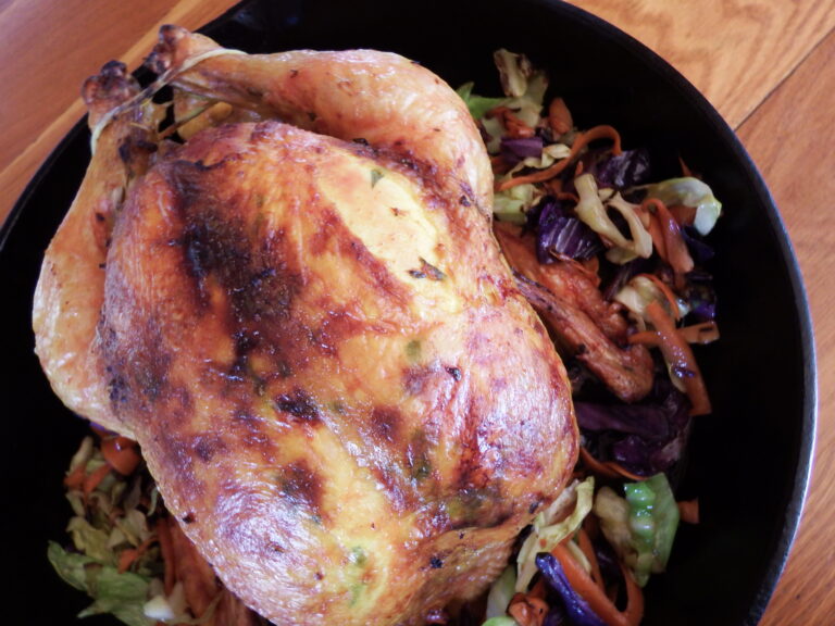 roasted chicken in cast iron skillet with shredded cabbage and carrots.