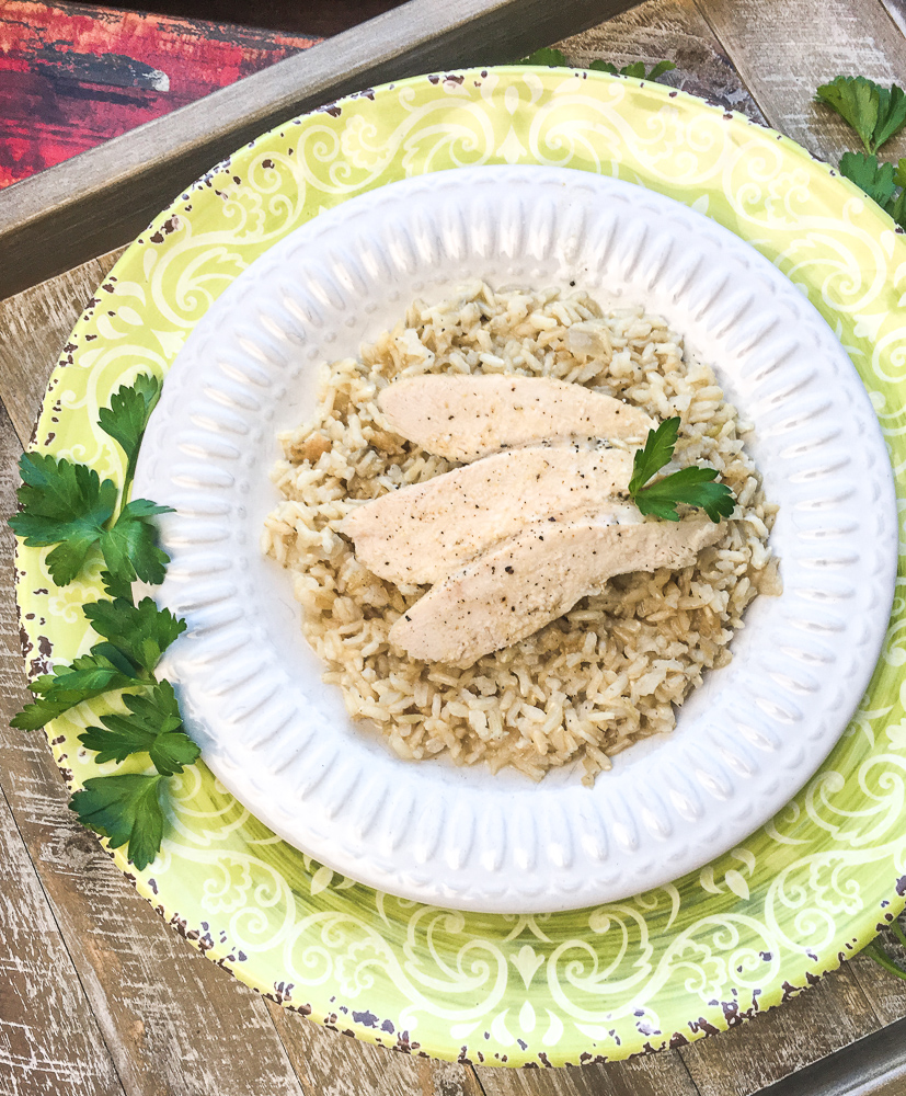 sliced chicken breast on bed of rice in serving dish