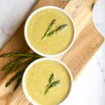 low histamine creamy asparagus soup in 2 bowls with garish of asparagus tops