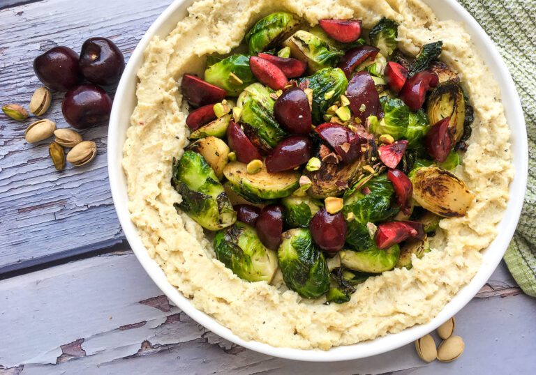 low histamine cauliflower mash topped with brussels sprouts, cherries and pistachios in serving dish